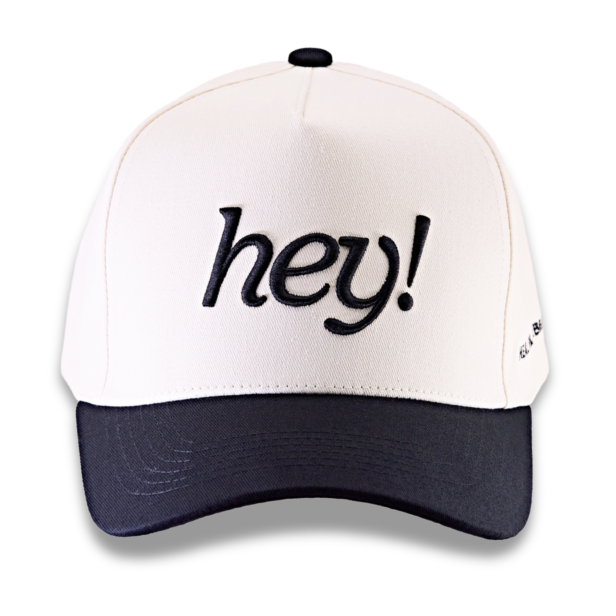 Front view of a black hat embroidered with “hey!”.
