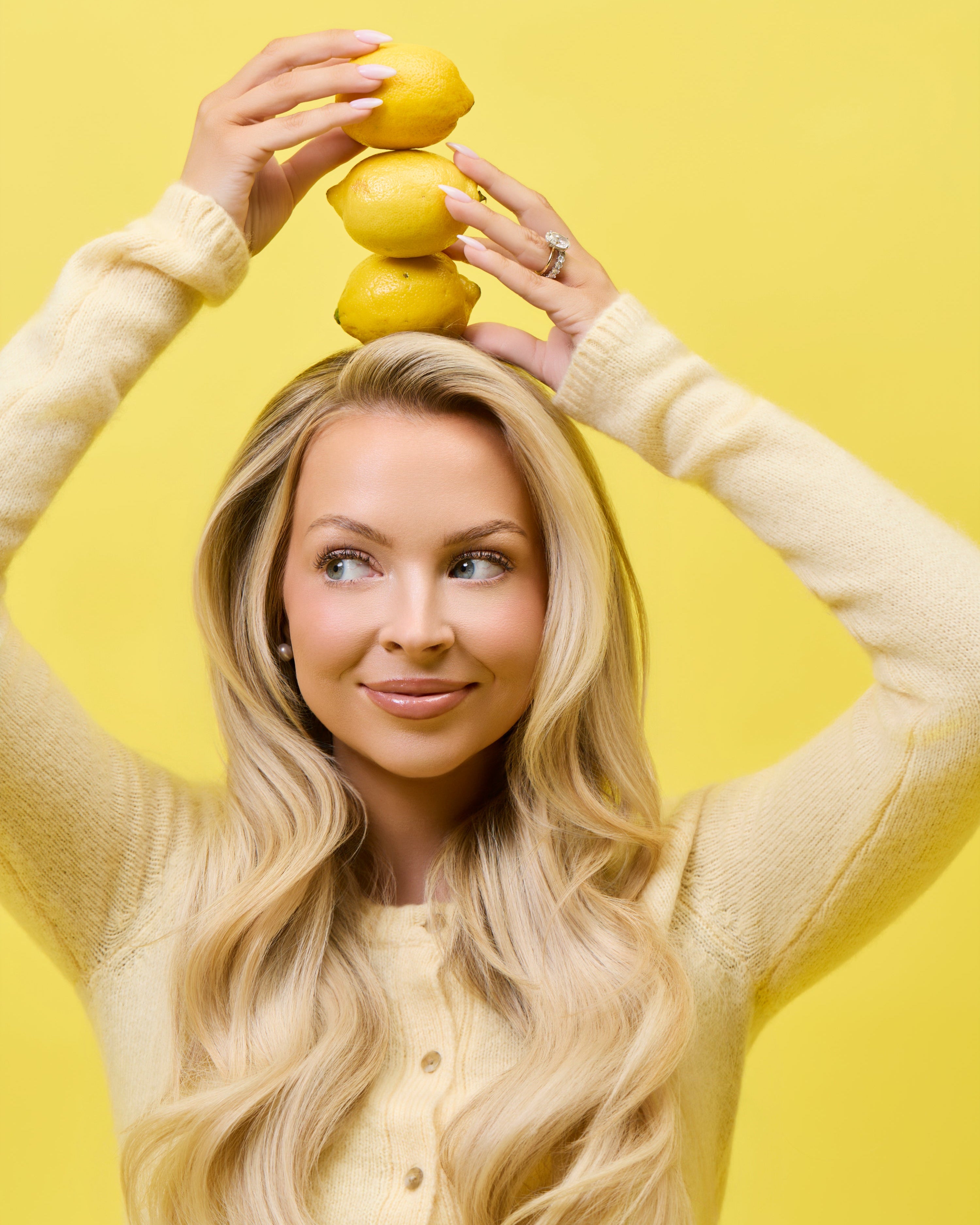 Kay Dudley, a woman holding lemons on a yellow background